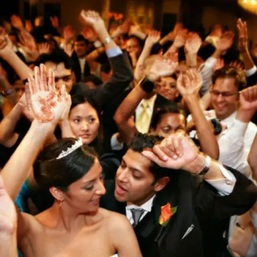 Wedding DJ Hire with Bride and groom dancing with guests at a wedding, capturing the spirit of love and celebration.